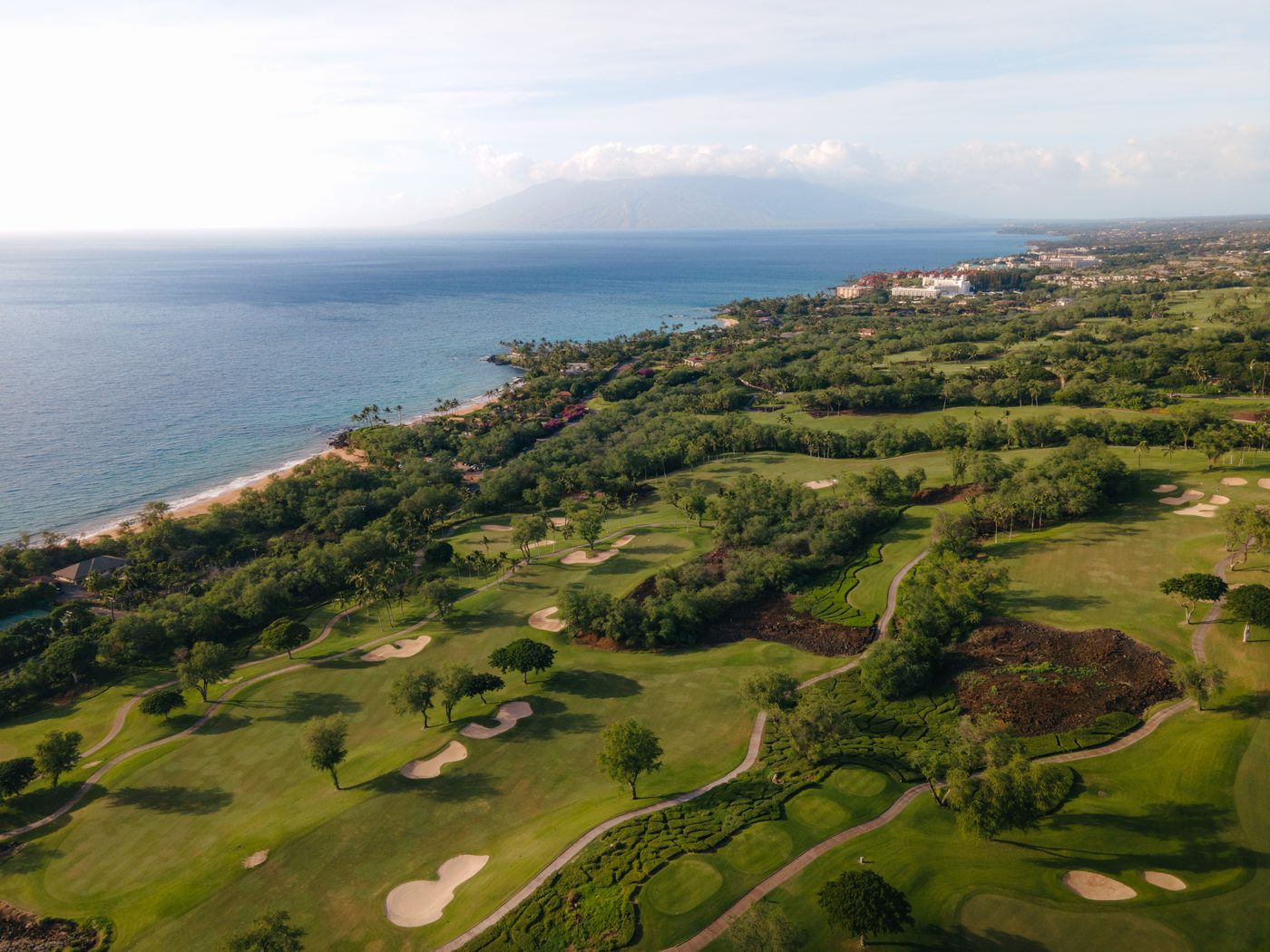 Golf fairways running down to the ocean coastline