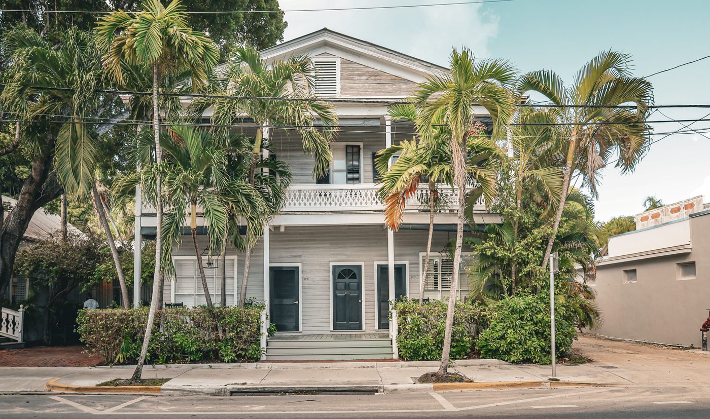 Classic Florida coastal porch house framed by palms, Key West
