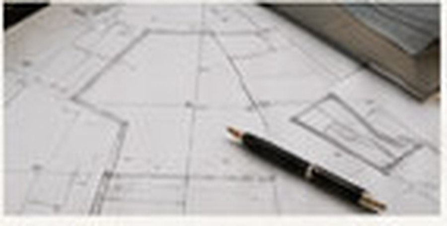 Architectural drawings with a pen resting on them