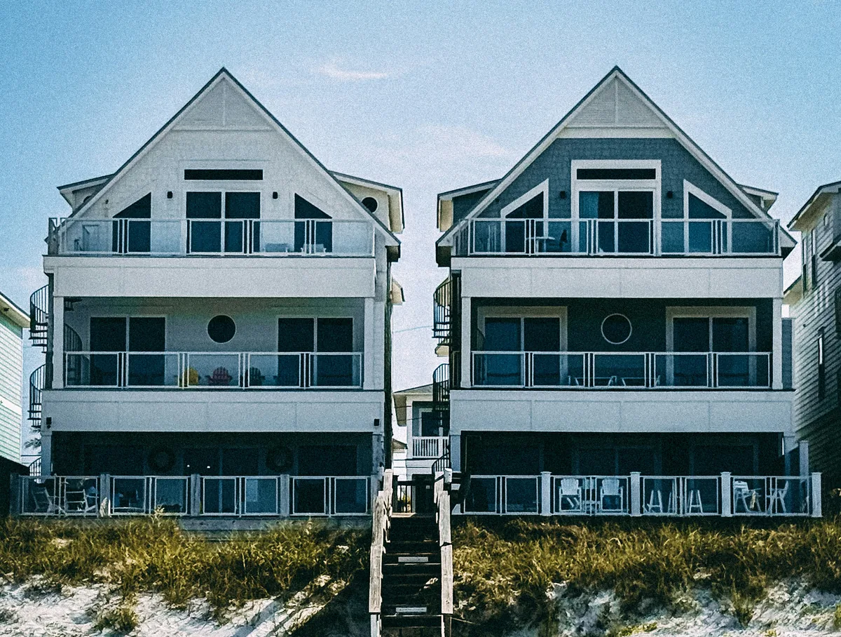 Illustrative pair of elevated coastal homes on the dunes