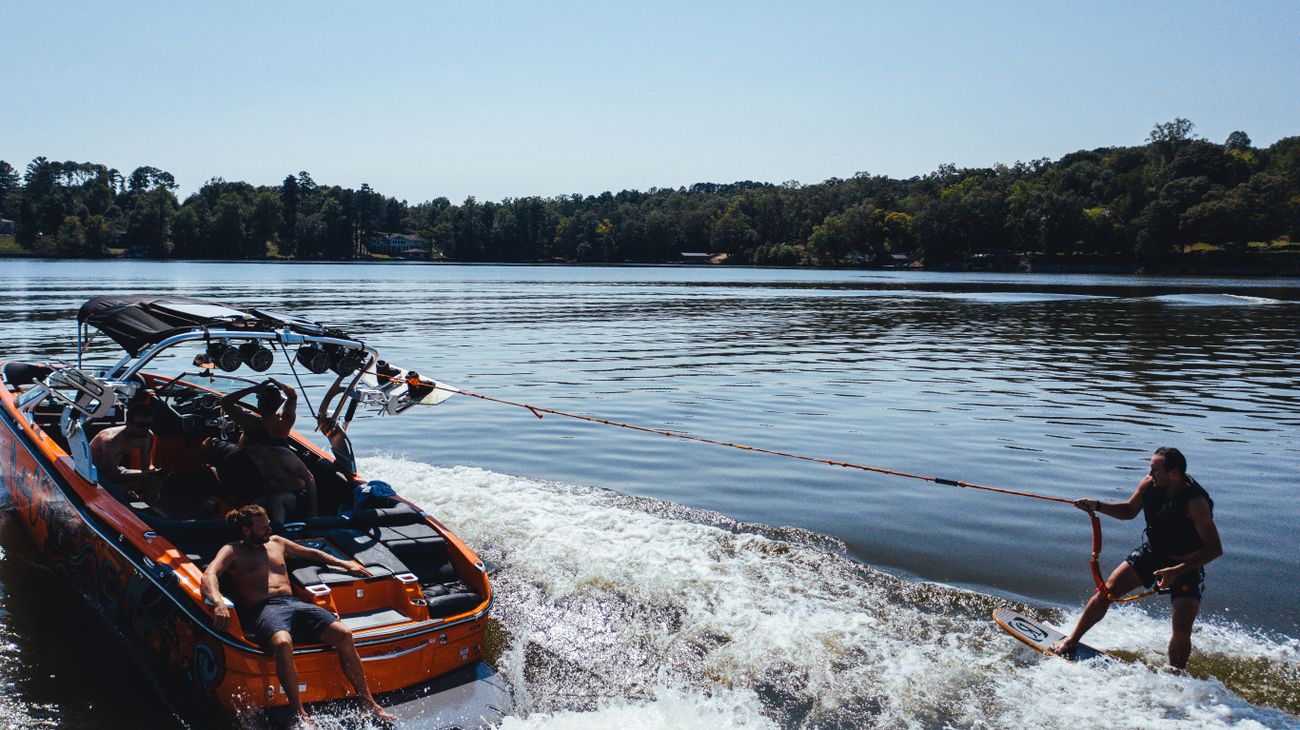 Wakesurfer riding behind an inboard wake boat on a South Florida lake
